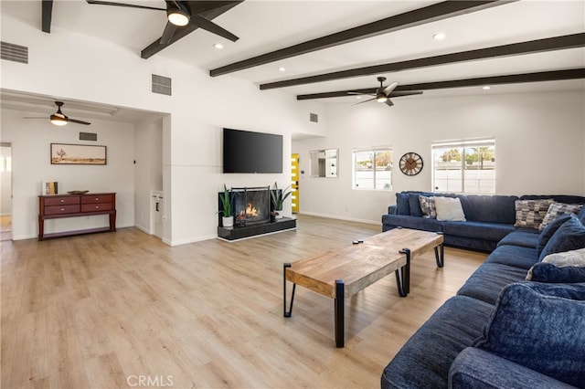 living room with lofted ceiling with beams and light hardwood / wood-style flooring