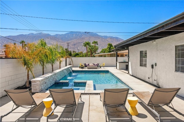 view of pool with pool water feature, a mountain view, an in ground hot tub, and a patio area