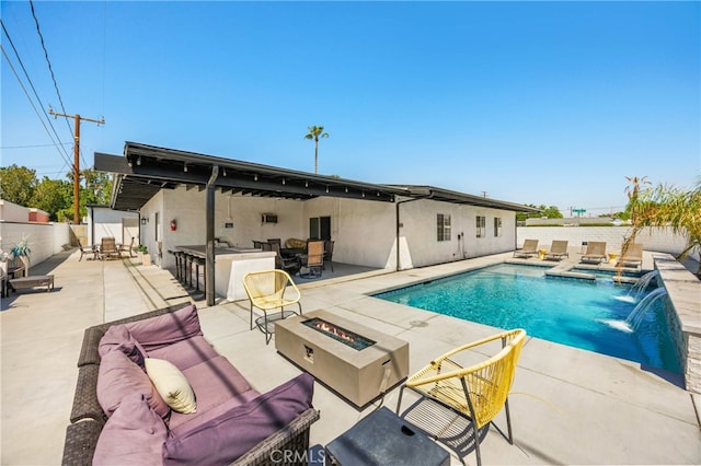 view of pool with a fire pit, a patio, and pool water feature