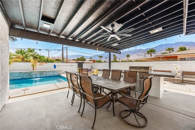 view of patio / terrace featuring a mountain view, a grill, pool water feature, a fenced in pool, and ceiling fan