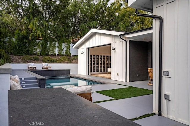 view of pool with an outbuilding, a patio, and a hot tub