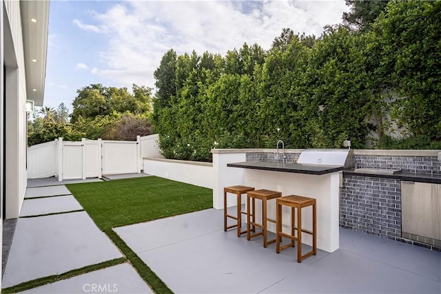 view of patio / terrace featuring an outdoor kitchen, a grill, and exterior bar