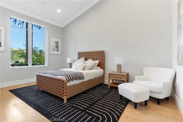 bedroom featuring wood-type flooring, vaulted ceiling, and ornamental molding