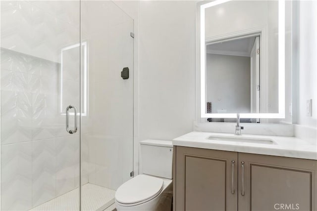 bathroom featuring ornamental molding, vanity, toilet, and a shower with shower door