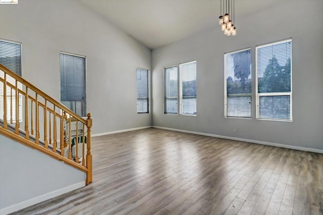 interior space featuring light wood-type flooring, vaulted ceiling, and plenty of natural light