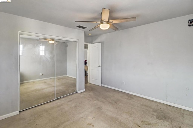 unfurnished bedroom with a closet, ceiling fan, and light colored carpet