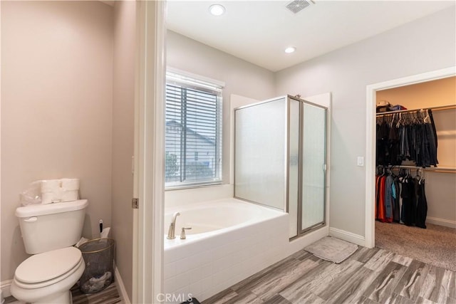 bathroom featuring hardwood / wood-style flooring, separate shower and tub, and toilet