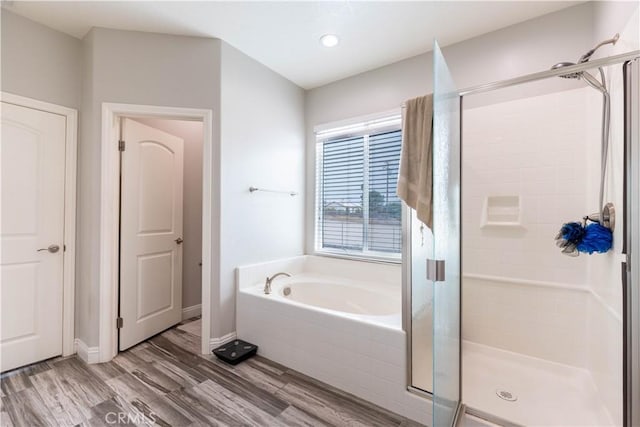 bathroom featuring hardwood / wood-style flooring and plus walk in shower