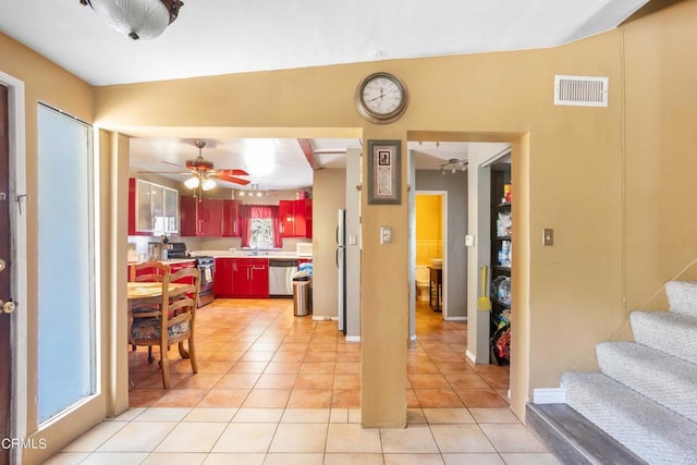 kitchen featuring ceiling fan, sink, lofted ceiling, light tile patterned floors, and appliances with stainless steel finishes