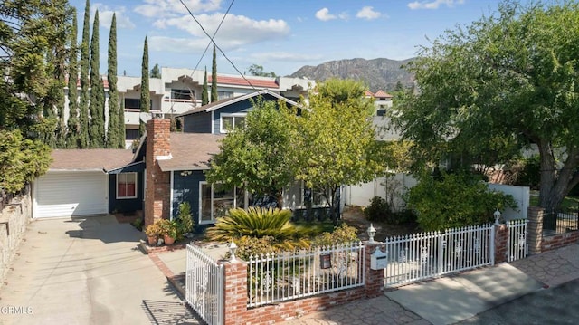 view of property hidden behind natural elements with a mountain view and a garage