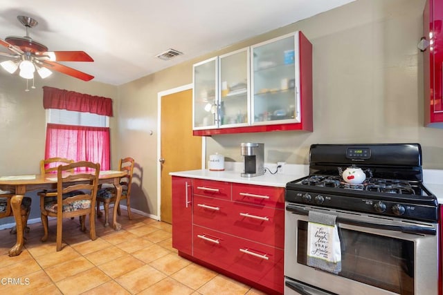 kitchen featuring light tile patterned floors, stainless steel gas stove, and ceiling fan