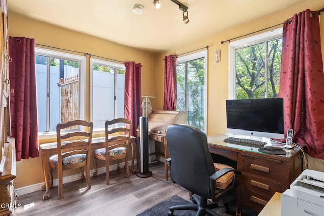 office space with rail lighting, a healthy amount of sunlight, and light hardwood / wood-style floors