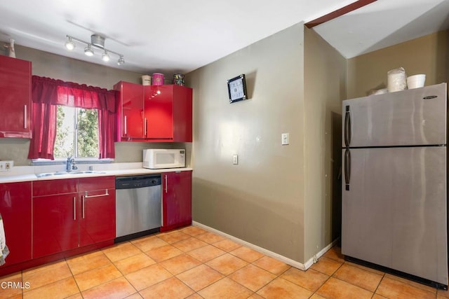 kitchen with sink, light tile patterned floors, and appliances with stainless steel finishes