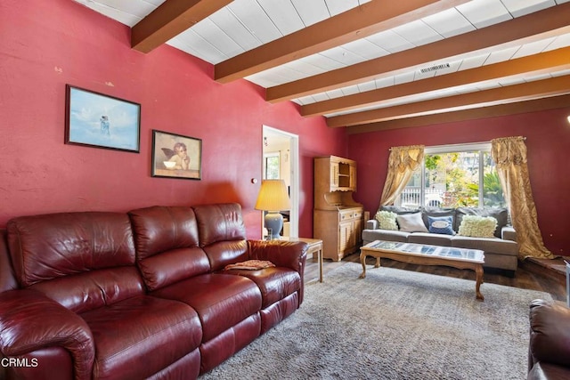 carpeted living room with beamed ceiling