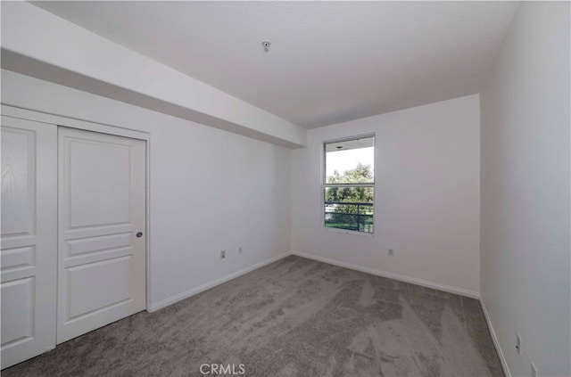 unfurnished bedroom featuring light carpet and a closet