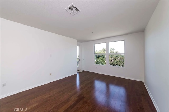 spare room featuring dark hardwood / wood-style flooring