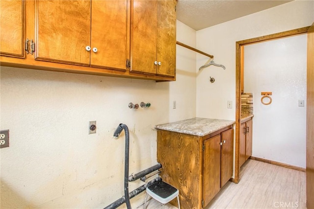 laundry area featuring cabinets, hookup for a washing machine, light hardwood / wood-style floors, and electric dryer hookup