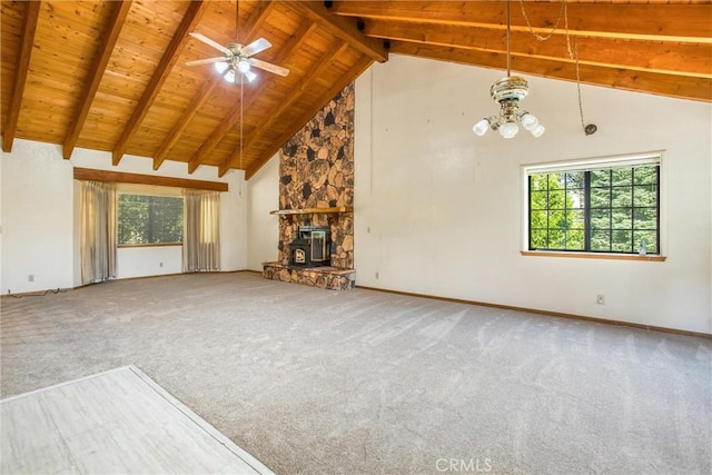 unfurnished living room featuring ceiling fan with notable chandelier, plenty of natural light, carpet floors, and beamed ceiling