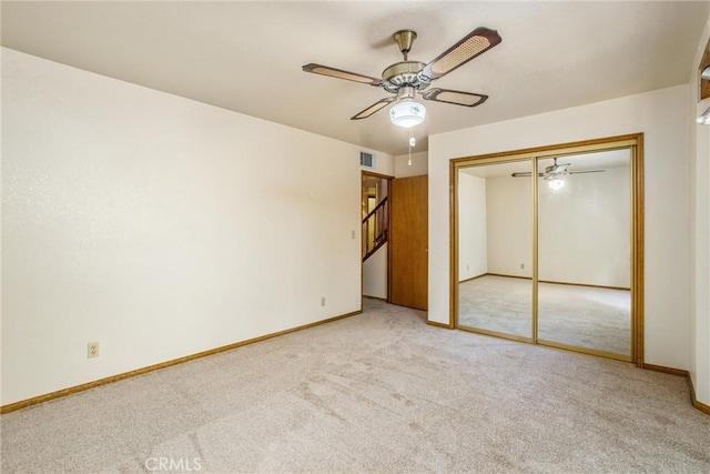 unfurnished bedroom with light carpet, a closet, and ceiling fan