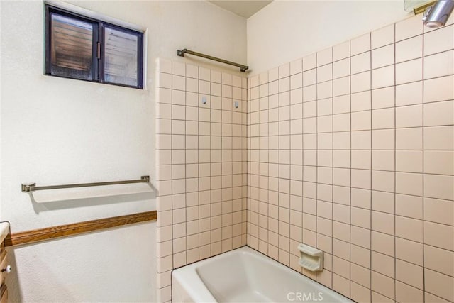 bathroom with vanity and tiled shower / bath