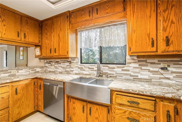 kitchen with stainless steel dishwasher, light stone counters, sink, and tasteful backsplash