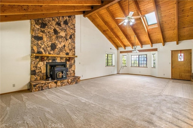 unfurnished living room featuring carpet, ceiling fan, beam ceiling, high vaulted ceiling, and a wood stove