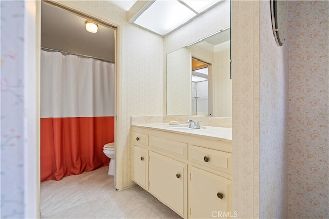 bathroom with walk in shower, vanity, and toilet