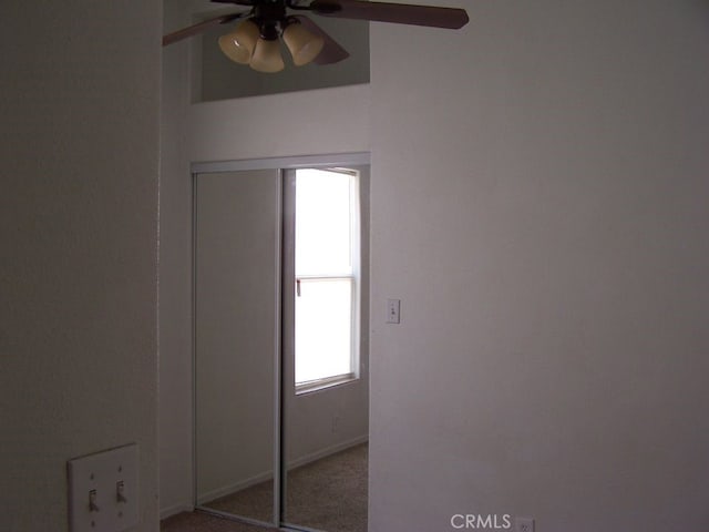 carpeted spare room featuring ceiling fan