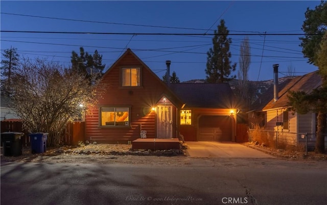 rustic home with faux log siding, driveway, an attached garage, and fence