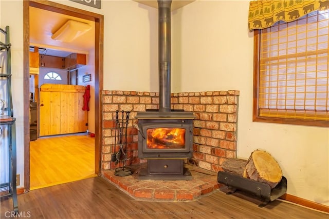 interior details featuring hardwood / wood-style floors and a wood stove