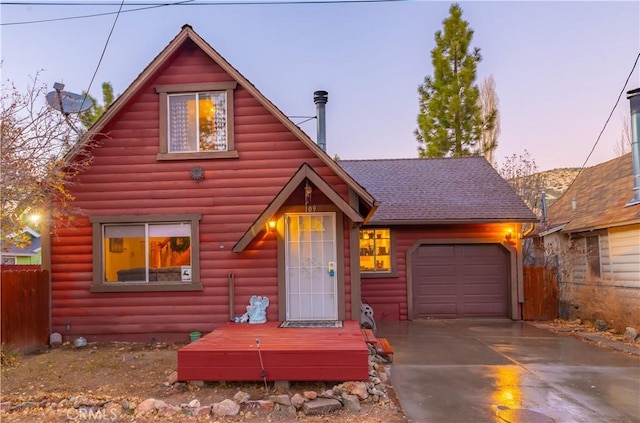 log home featuring fence, roof with shingles, driveway, an attached garage, and log veneer siding