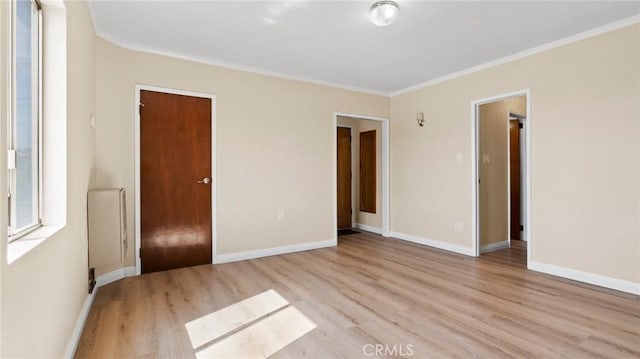 unfurnished bedroom featuring crown molding, a closet, and light wood-type flooring