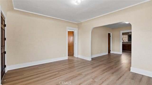 empty room with ornamental molding and light hardwood / wood-style flooring