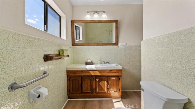 bathroom featuring hardwood / wood-style floors, vanity, tile walls, and toilet