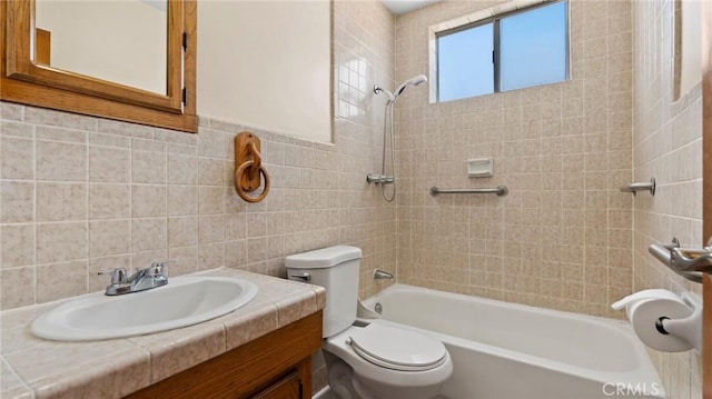 full bathroom featuring vanity, tiled shower / bath combo, toilet, and tile walls