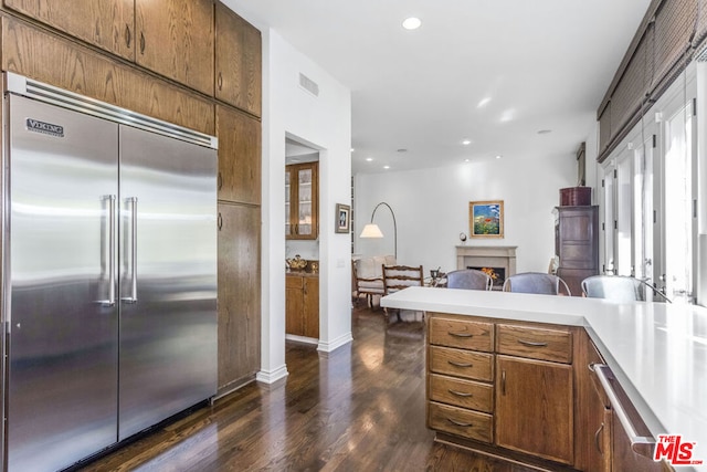 kitchen featuring stainless steel built in refrigerator and dark wood-type flooring