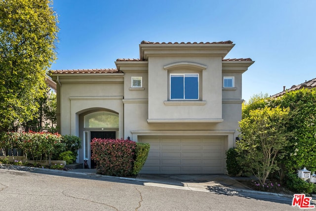 mediterranean / spanish-style home with a garage