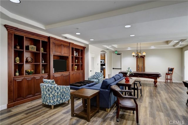 living room featuring billiards, wood-type flooring, and a tray ceiling