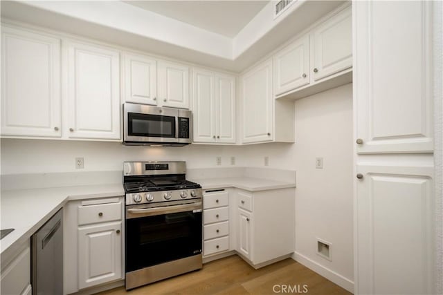 kitchen featuring white cabinetry, appliances with stainless steel finishes, and light hardwood / wood-style flooring