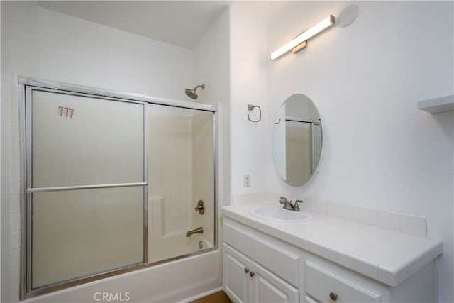 bathroom featuring enclosed tub / shower combo and vanity