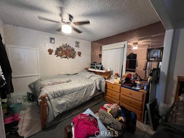 bedroom featuring a ceiling fan and a textured ceiling