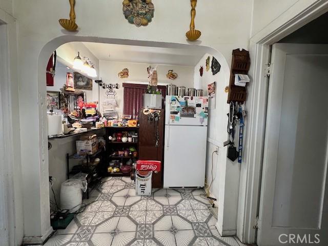 kitchen with arched walkways and freestanding refrigerator