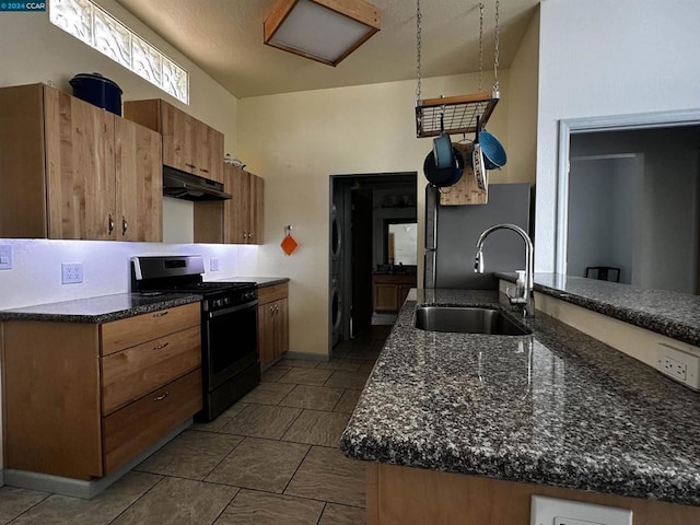 kitchen featuring dark tile patterned flooring, sink, and black range with gas cooktop