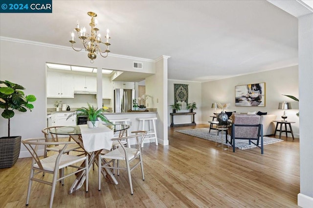 dining room featuring an inviting chandelier, crown molding, and light wood-type flooring