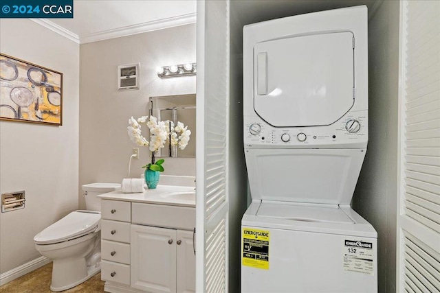 laundry area with crown molding, stacked washer and dryer, and tile patterned flooring