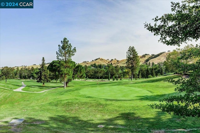 surrounding community with a yard and a mountain view