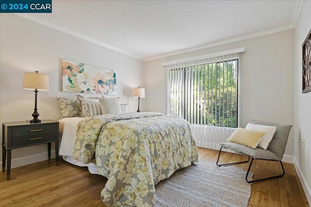 bedroom with crown molding and hardwood / wood-style flooring