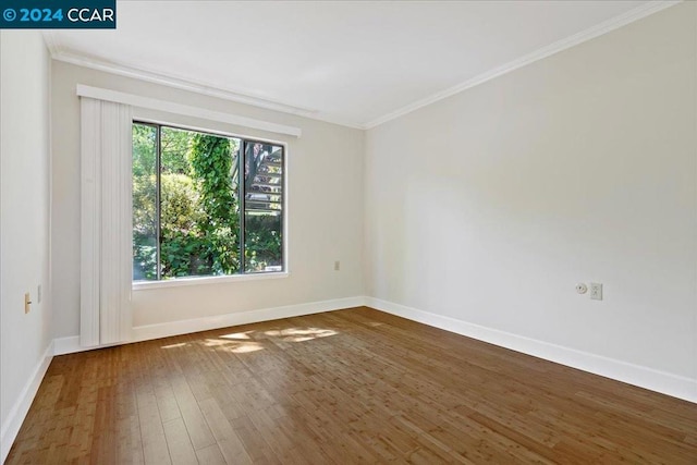 spare room with crown molding and dark hardwood / wood-style flooring