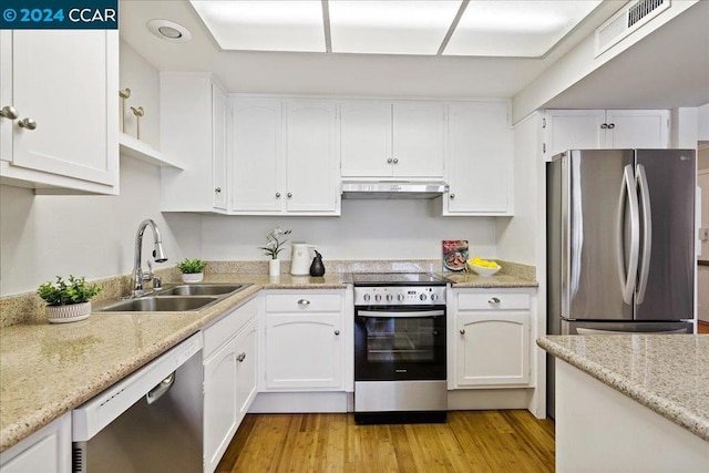 kitchen featuring appliances with stainless steel finishes, light hardwood / wood-style flooring, white cabinets, and sink