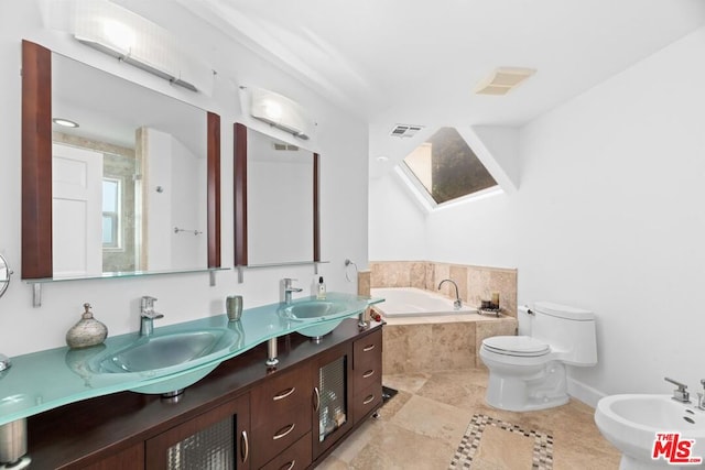 bathroom with tiled tub, toilet, vanity, and a bidet